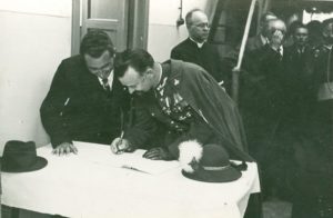 Fotografia uroczystości w fabryce z ok 1937 r. podpis składa płk Zygmunt Cšadek