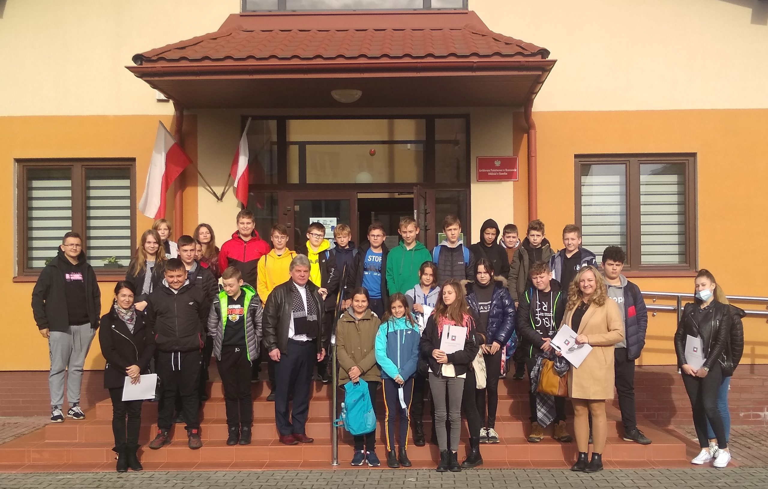 grupa uczniów Szkoły Podstawowej w Prusieku przed budynkiem Oddziału w Sanoku przy ul. Sadowej 32