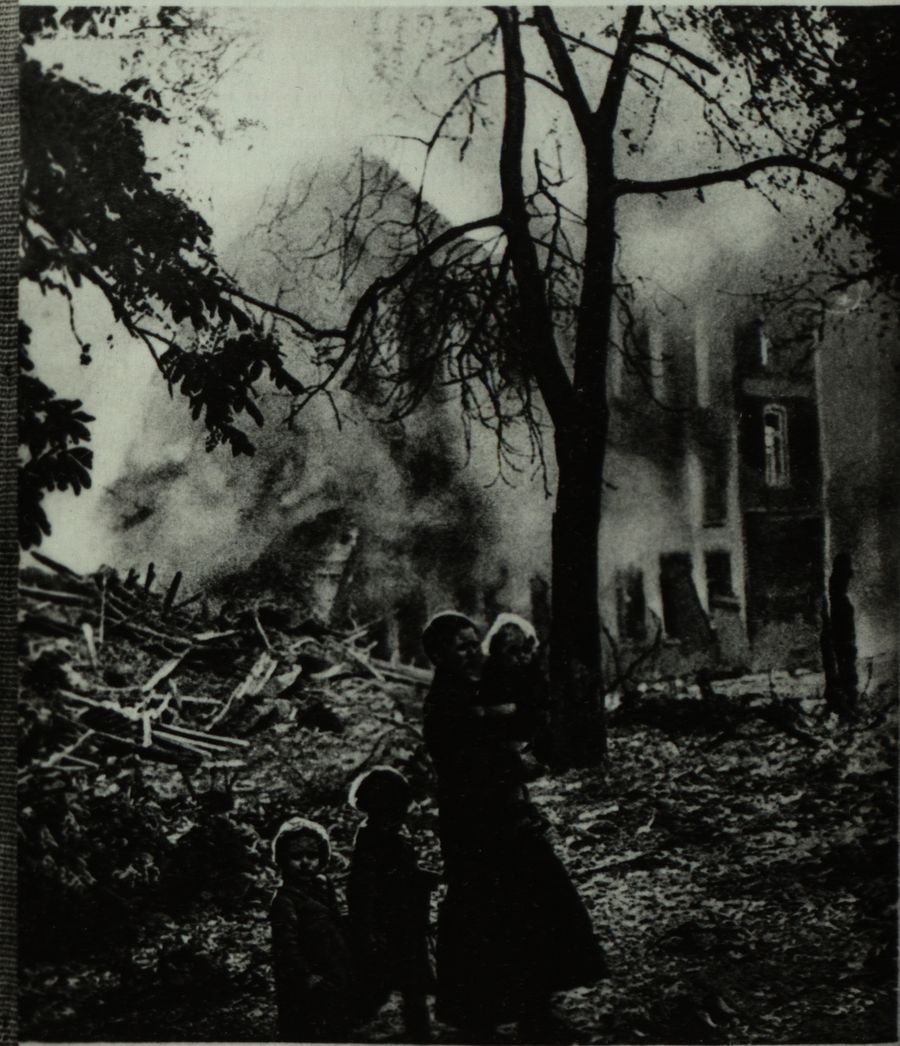 Matka z dziećmi na tle płonącego budynku