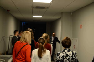 Grupa osób stoi w korytarzu Archiwum słuchając oprowadzającego